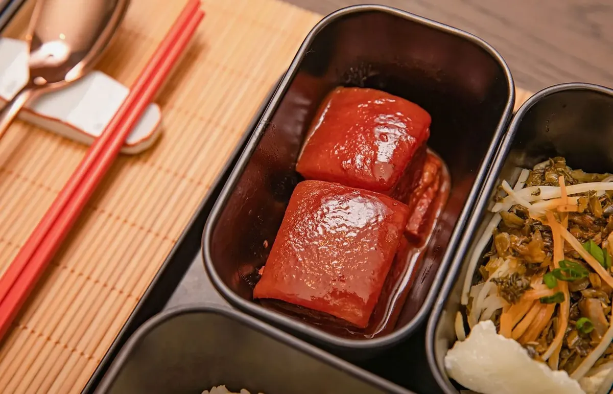煮込んだ肉と副菜が入った弁当容器