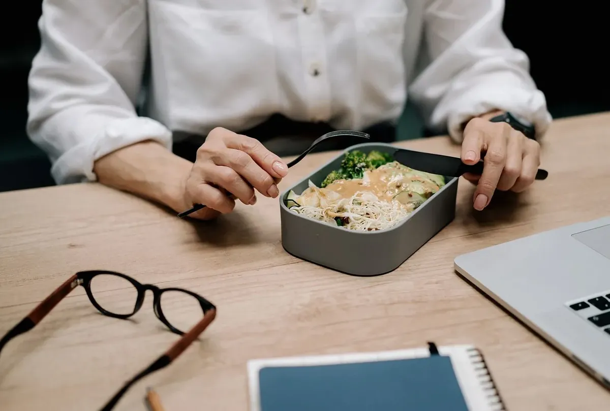 机の上で弁当を食べる人